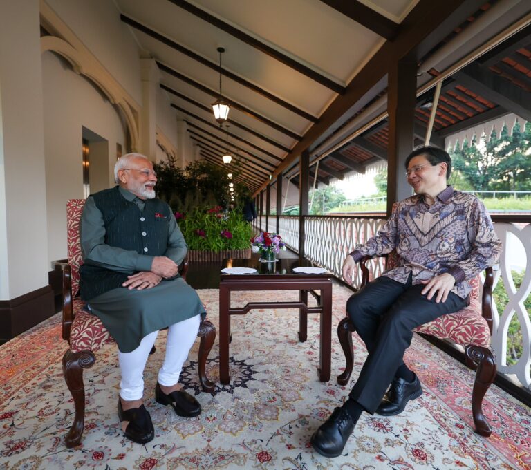 "Prime Minister Narendra Modi playing dhol during Lavani dance performance in Singapore, welcomed by Indian diaspora."